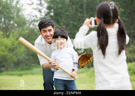 Girl taking pictures of father and brother Stock Photo