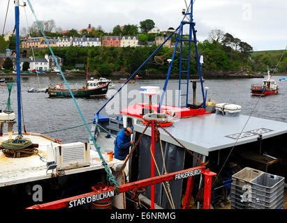 The 47-year-old  'Catriona' being given a lick of paint in Portree Harbour,Isle of Skye, Scotland Stock Photo