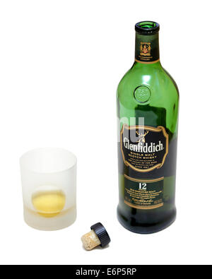 Opened bottle of 12 year old Glenfiddich Single Malt Scotch Whisky next to a glass of whisky isolated on white background  Model Release: No.  Property Release: No. Stock Photo