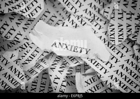 Torn pieces of paper with the word 'Anxiety'. Concept Image. Black and White. Stock Photo