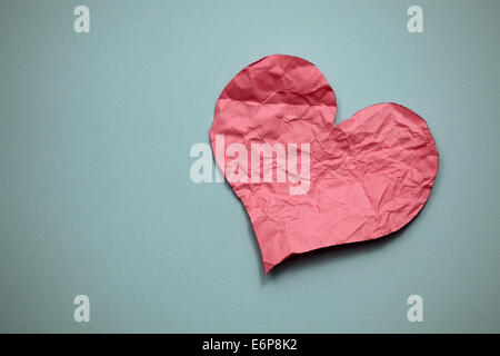 Crumpled paper heart on paper background. Stock Photo