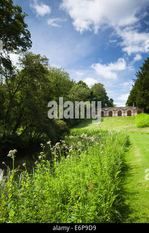 The seven-arch arcade (Praeneste) designed by William Kent seen from beside the River Cherwell at Rousham House in Oxfordshire, England Stock Photo