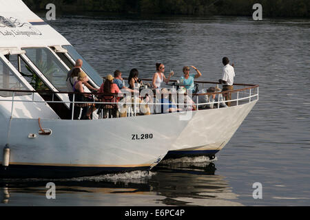 Cruise along the Victoria Falls aboard the ' African Queen'.  Other boats sailing in the Zambezi River. This is the “Lady Living Stock Photo