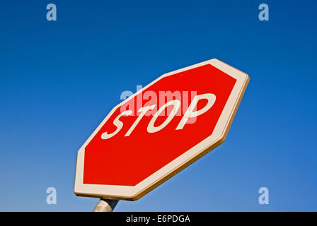 Red octagonal STOP sign against a blue sky Stock Photo