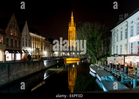 The tower of the Church of our Lady of Bruges reflected in a canal at night Stock Photo