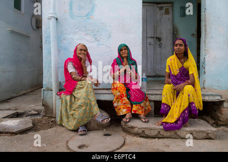 Group of local Indian women sitting on the steps of a house, chatting, in Udaipur, Rajastan, India Stock Photo