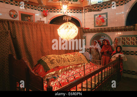 Muslim women praying on the tomb of a respected muslim man ( Pakistan) Stock Photo