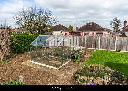 Empty green house and vegetable plot ready for growing in a back garden in Northborough, Cambridgeshire, England, UK. Stock Photo