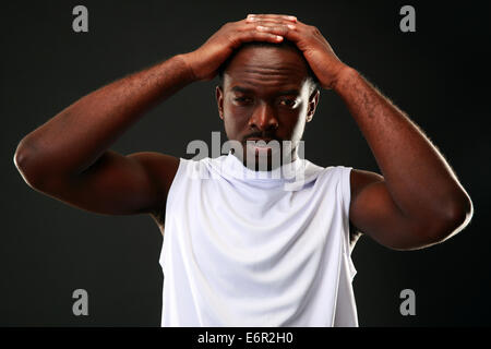 Frustrated african man touching his head over black background Stock Photo