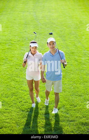 Portrait of young couple with golf clubs Stock Photo