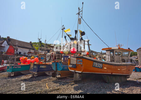 Colourful fishing boats hauled up on the beach at Cadgwith Cove on the Lizard Peninsula Cornwall England UK Stock Photo