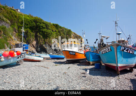 Colourful fishing boats hauled up on the beach at Cadgwith Cove on the Lizard Peninsula Cornwall England UK Stock Photo