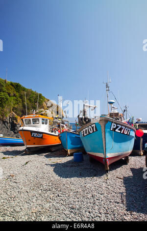 Colourful fishing boats hauled up on the beach at Cadgwith Cove on the Lizard Peninsula Cornwall England UK Stock Photo