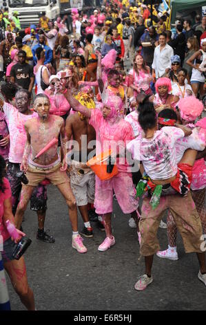 Crowd of people covered in pick and white paint at Notting Hill Carnival on family day Stock Photo