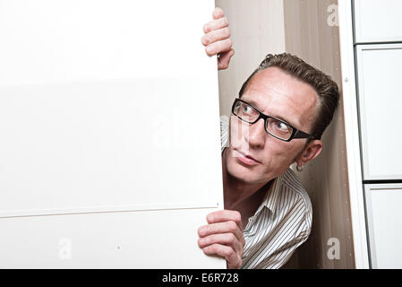 Surprised man inside white wardrobe. Stock Photo