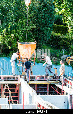 workers at construction site pouring concrete in form Stock Photo
