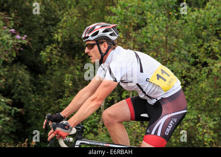 A Millennial man wearing Lycra and a cycle helmet racing in a local bike race organised by British Cycling. England UK Britain Stock Photo