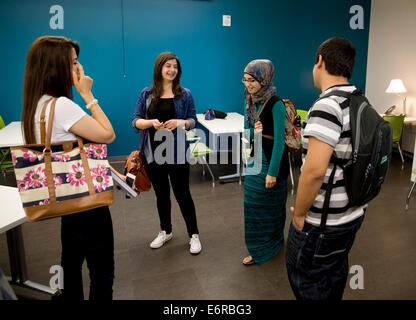 Small group of students, including a female wearing a Hijab, talk in the student lounge at the new Austin Community College Stock Photo