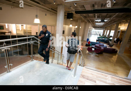 Austin Community College police officer patrols hallways, speaks to students at new campus building in Austin, Texas Stock Photo