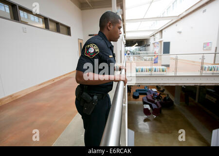 Austin Community College police officer patrols hallways, speaks to students at new campus building in Austin, Texas Stock Photo