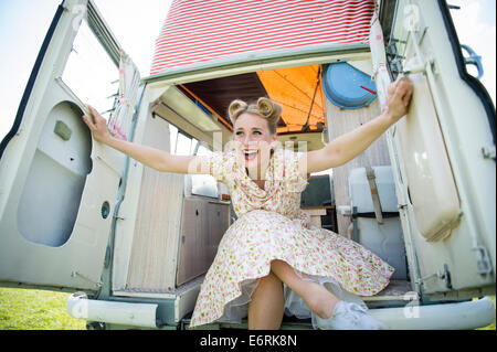 A retro woman dressed in a 50s vintage inspired dress, holding up