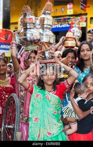 Young girls in colourful clothes carrying pot on their heads in a traditional wedding procession in Deogarh, Rajasthan, India Stock Photo