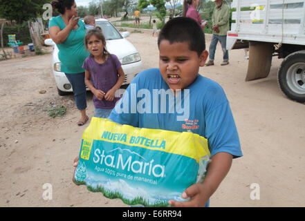 (140830) -- SONORA, Aug. 30, 2014 (Xinhua) -- Image taken on Aug. 19, 2014, of a boy carrying a package of purified water granted by Grupo Mexico, after a toxic spill in the Sonora River, in the San Pedro de Ures village, Sonora, Mexico. According to the Federal Government, on Aug. 6, 2014, the largest environmental disaster in the mining industry in Mexico was recorded, when 40,000 cubic meters of copper sulfate were spilled into a damm of the miner property of Grupo Mexico, contaminating parts of the Tinajas creek, the Bacanuchi River and the Sonora River. According to a dictum of the Federa Stock Photo