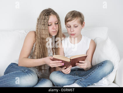 Boy and girl sitting on library floor reading books Stock Photo - Alamy