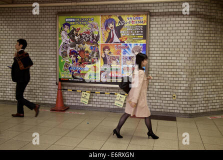 People, commuters in subway train station and sign, poster, billboard, advertising with manga comics. Tokyo, Japan, Asia Stock Photo