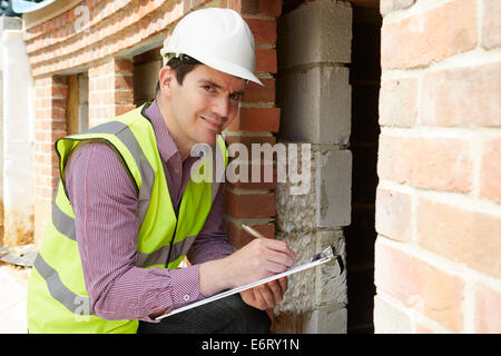 Architect Checking Insulation During House Construction Stock Photo