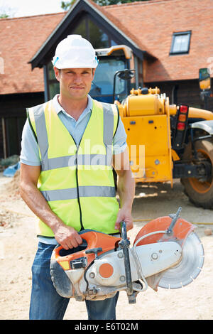 Construction Worker On Site Holding Circular Saw Stock Photo