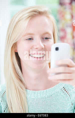 Smiling Young Woman Reading Text Message Stock Photo