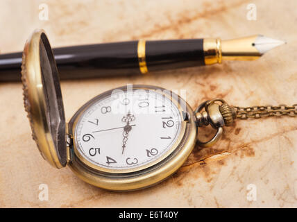 fountain pen and pocketwatch on old sheet Stock Photo