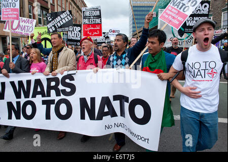 Newport, UK. 30th August, 2014. Peace Supporters march against NATO war policies ahead of the NATO summit at the Celtic Manor which will be attended by 60 world leaders next week. Worldwide Peace Supporters will take part in a week of peaceful protest and alternative Peace Summit. A 12 mile ‘ring of steel’ fence is in place at key sites and 9,500 police officers drawn from all 43 police forces in England and Wales. Credit:  Graham M. Lawrence/Alamy Live News. Stock Photo