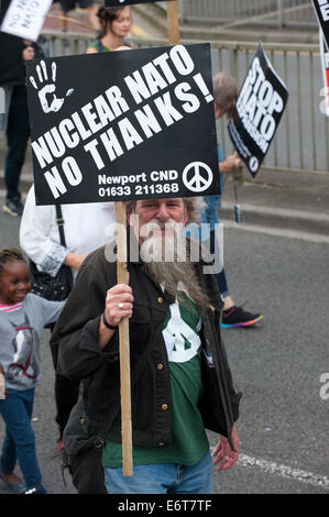Newport, UK. 30th August, 2014. Peace Supporters march against NATO war policies ahead of the NATO summit at the Celtic Manor which will be attended by 60 world leaders next week. Worldwide Peace Supporters will take part in a week of peaceful protest and alternative Peace Summit. A 12 mile ‘ring of steel’ fence is in place at key sites and 9,500 police officers drawn from all 43 police forces in England and Wales. Credit:  Graham M. Lawrence/Alamy Live News. Stock Photo