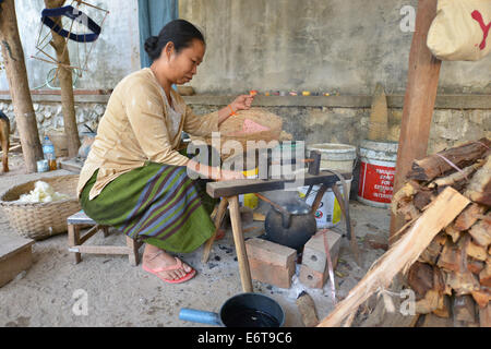 Luang Prabang, Laos - March 1, 2014: Woman preparing thread for weaving in silk in Luang Prabang, Laos. Stock Photo