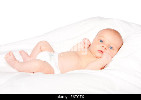 Cute baby infant laying on white pillow wearing diaper. Stock Photo