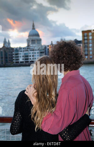 A young couple looking out over the Thames and St. Paul's cathedral in London Stock Photo