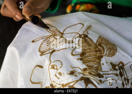 Yogyakarta, Java, Indonesia.  Batik Production.  Woman Using Hot Wax to Outline a Design on a Batik Cloth. Stock Photo