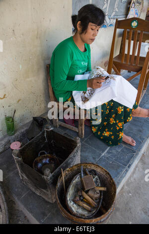 Yogyakarta, Java, Indonesia.  Batik Production.  Woman Using Hot Wax to Outline a Design on a Batik Cloth. Stock Photo