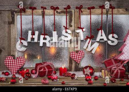 Country style christmas decoration in red, white, checkered and wood on an old windowsill. Stock Photo