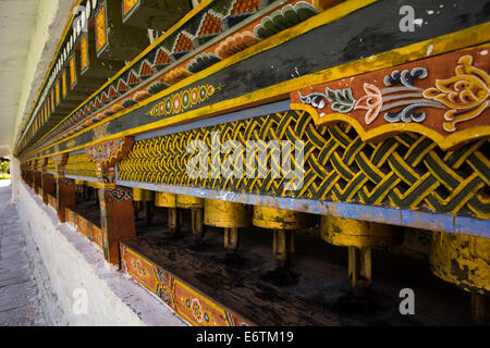 Eastern Bhutan, Trashi Yangtse, Chorten Kora, line of prayer wheels around stupa Stock Photo