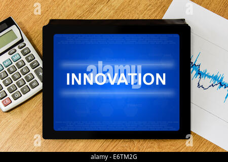 innovation word on digital tablet with calculator and financial graph Stock Photo