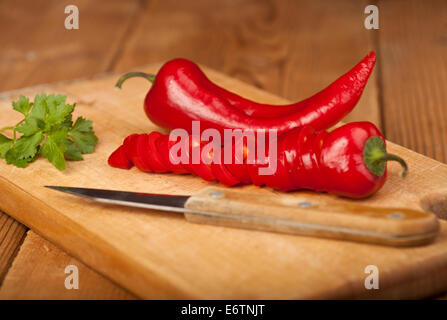 Red Hot Chili Peppers on a cutting board and wooden background. Stock Photo