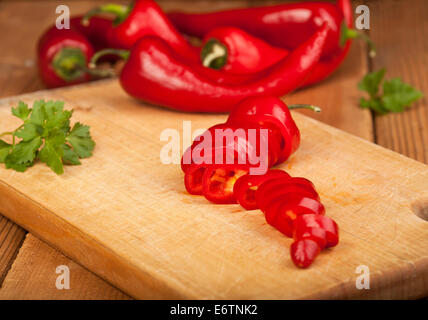 Red Hot Chili Peppers on a cutting board and wooden background. Stock Photo