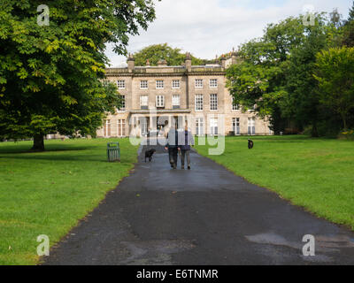 Couple walking dogs towards Haigh Hall Wigan Greater Manchester England UK Stock Photo