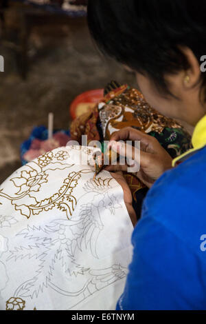 Yogyakarta, Java, Indonesia.  Woman Applying Wax to Design on Batik Cloth. Stock Photo