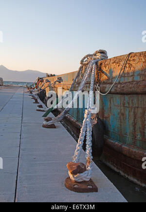 Old sisal ropes on a old rustic and rusty cargo boat in the port. Stock Photo