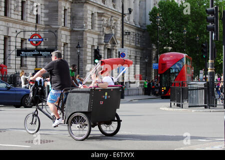 A cycle cab waiting to turn right on a road in Westminster, London Stock Photo