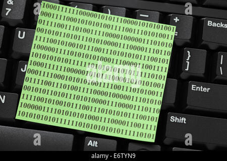 Sticky note with binary code on keyboard. Closeup. Stock Photo